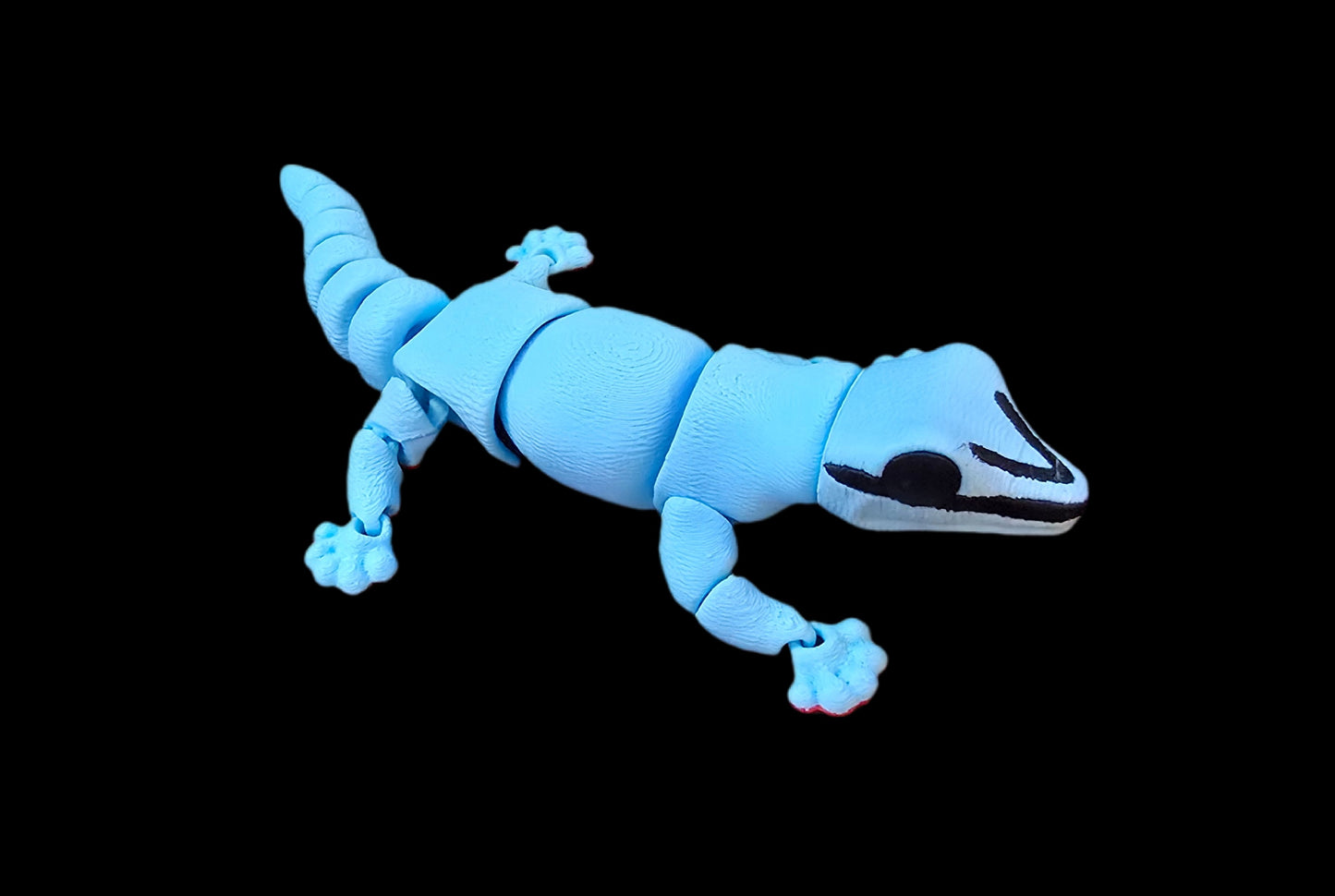 Blue magnetic toy lizard on a black background