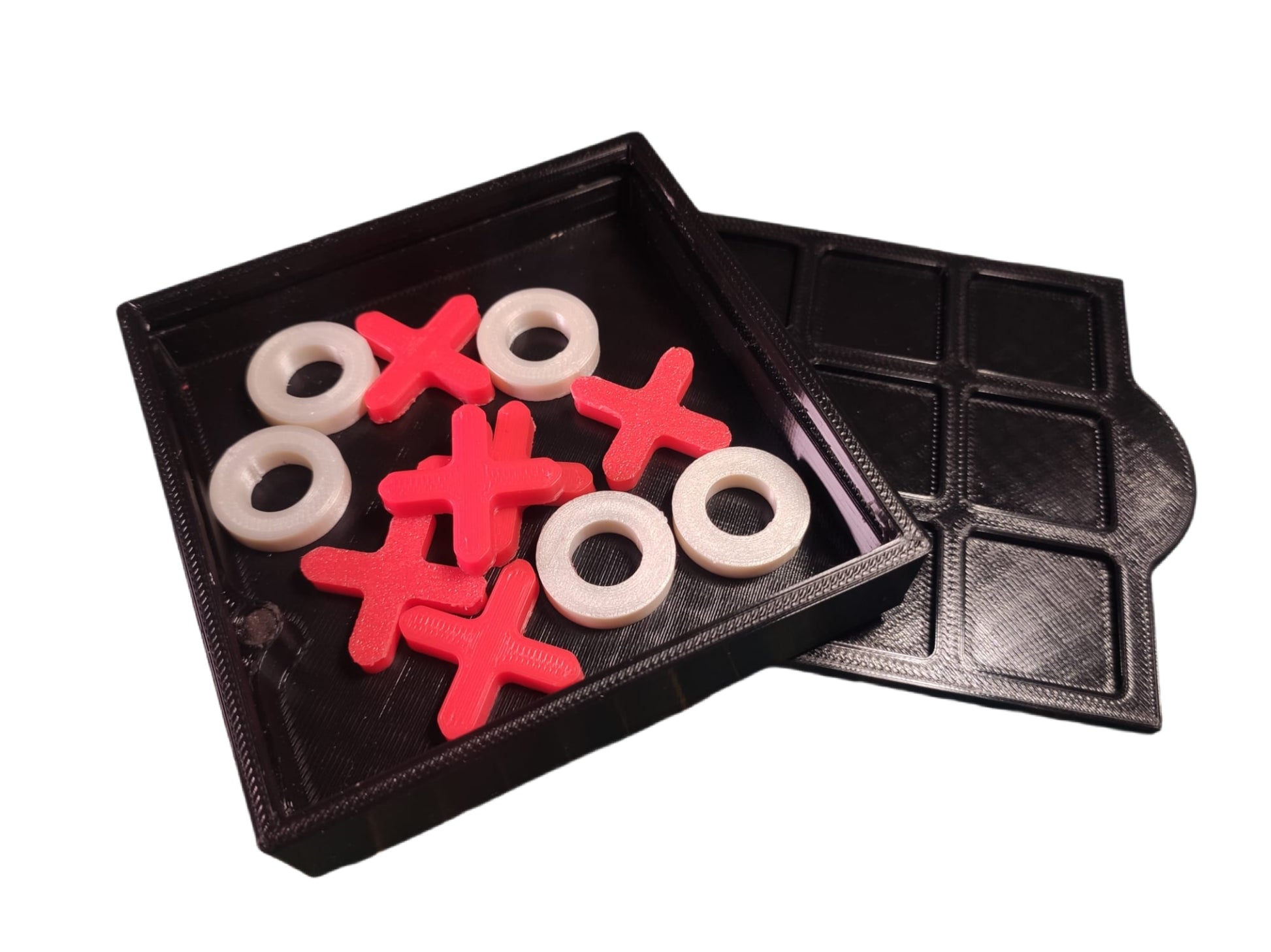 Board game pieces with 'X' and 'O' symbols in a black tray on a white background