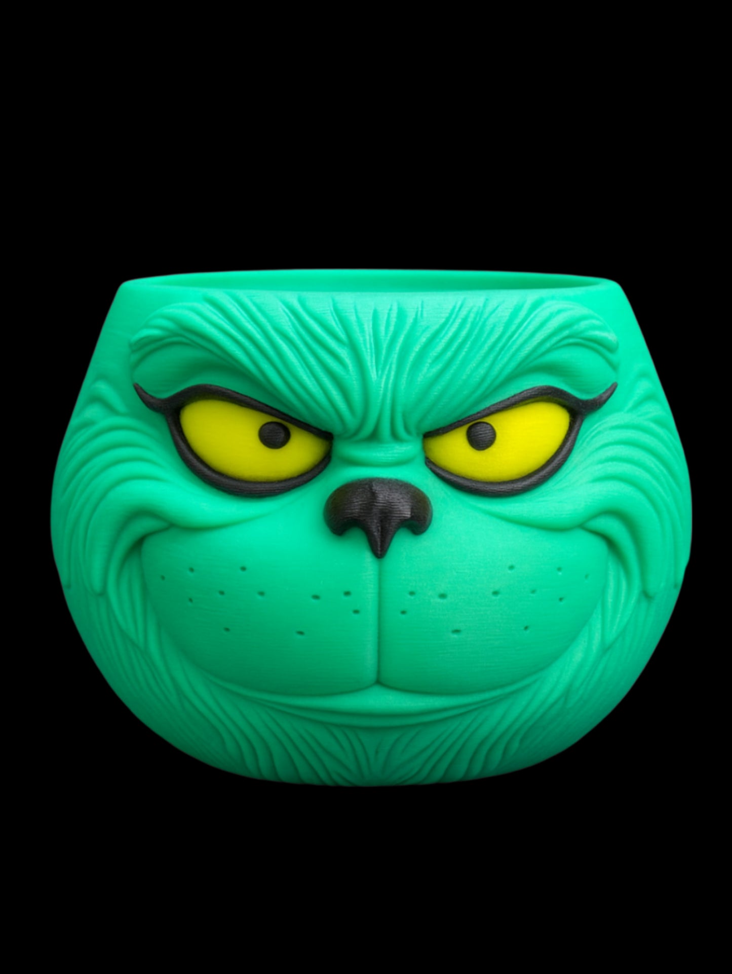 Green character face with yellow eyes and black pupils on a black background