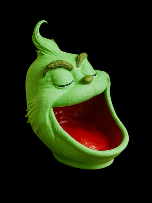 Green mask with a wide open mouth on a black background