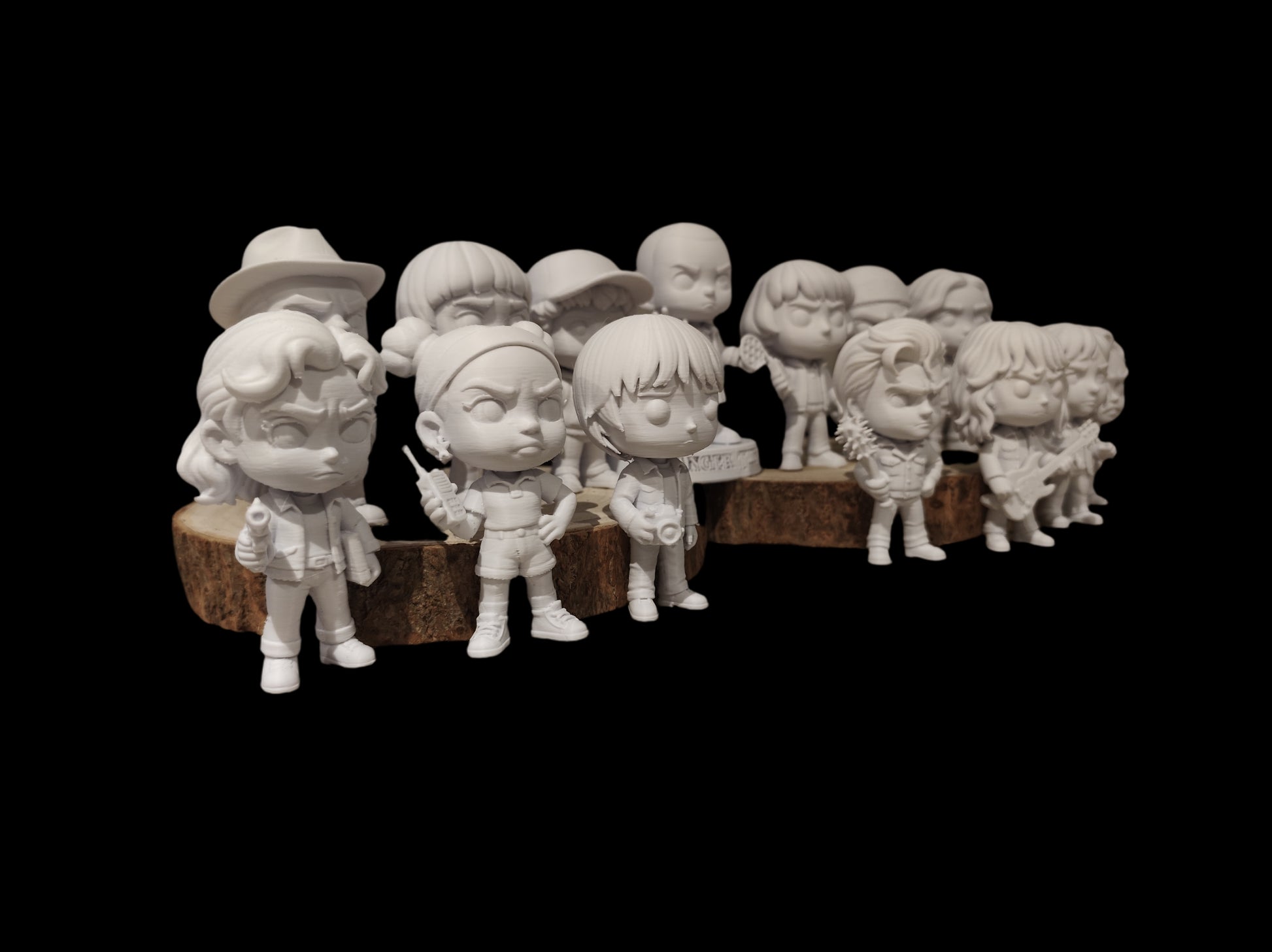 Set of white figurines on a wooden base against a black background