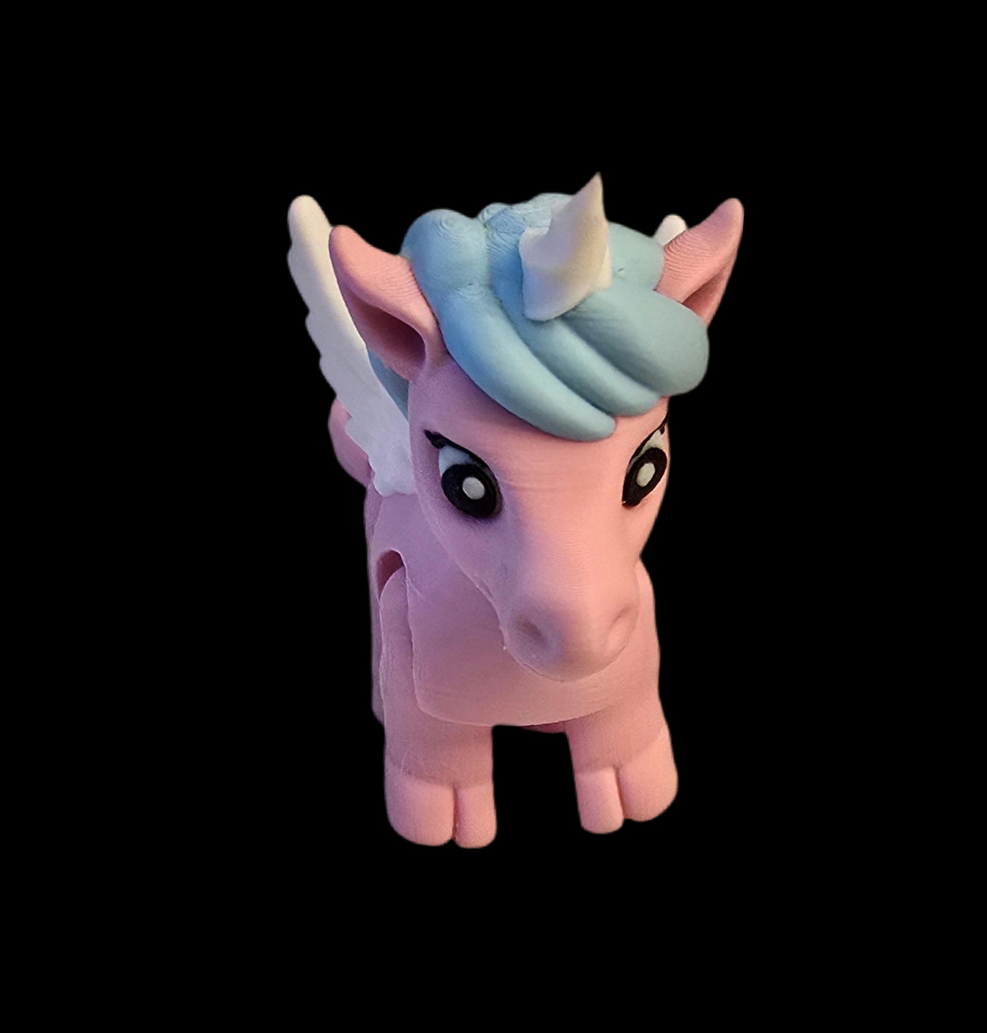 Pink unicorn figurine with blue hair and white wings on a black background