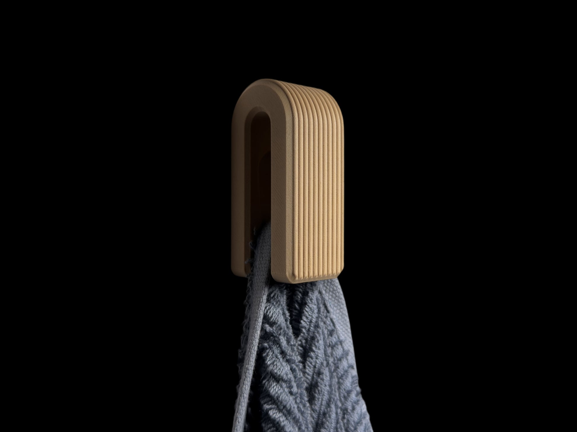 3d printed hook with a gray towel on a black background