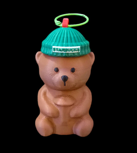 Teddy bear with a green Starbucks beanie on a black background