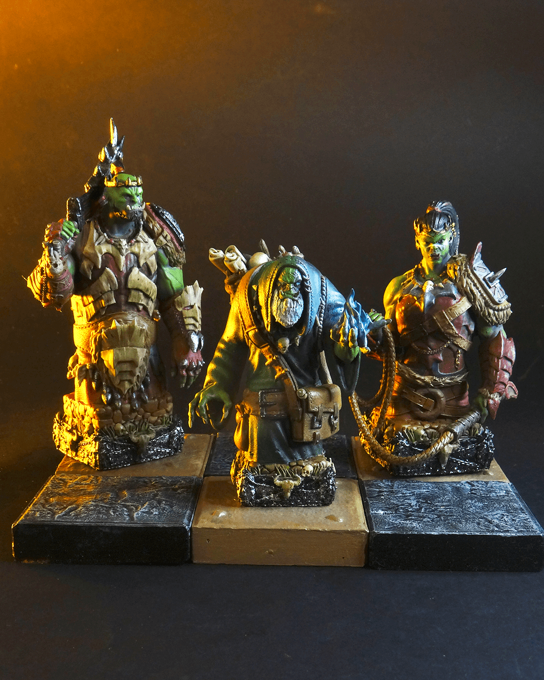 Three detailed miniature figures on a dark background