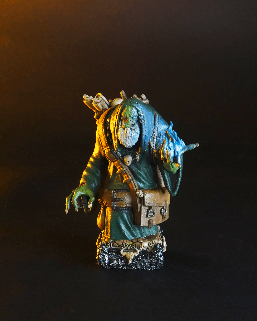 Miniature figurine with green skin and blue hair on a dark background
