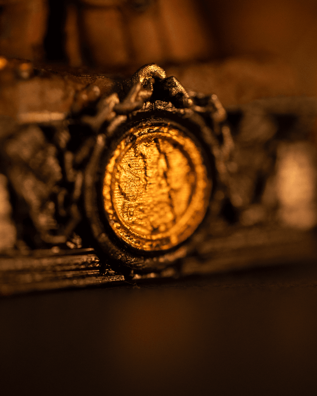 Close-up of a gold coin encased in a metal holder with a blurred background