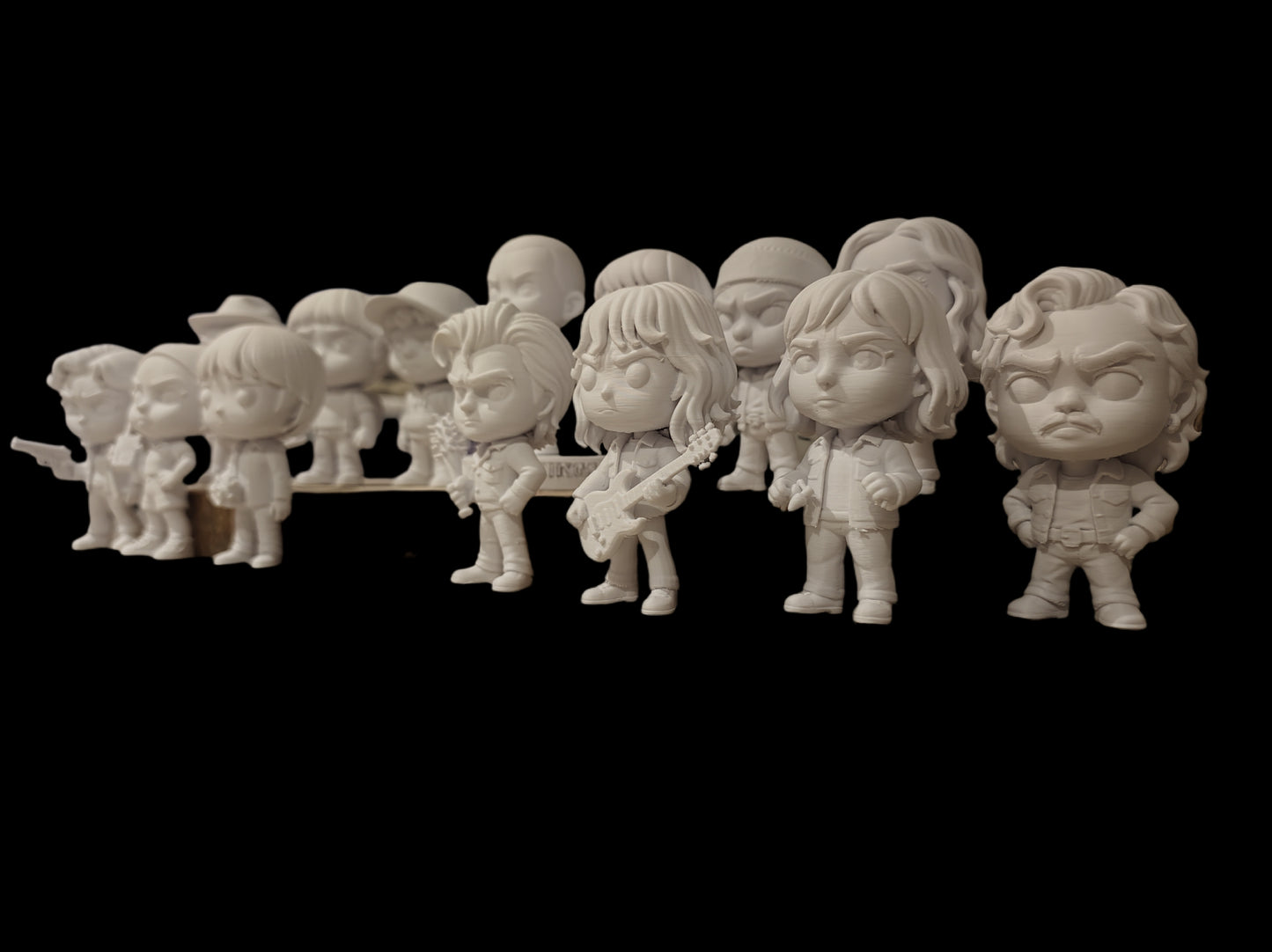 Row of cartoon-style figurines on a black background