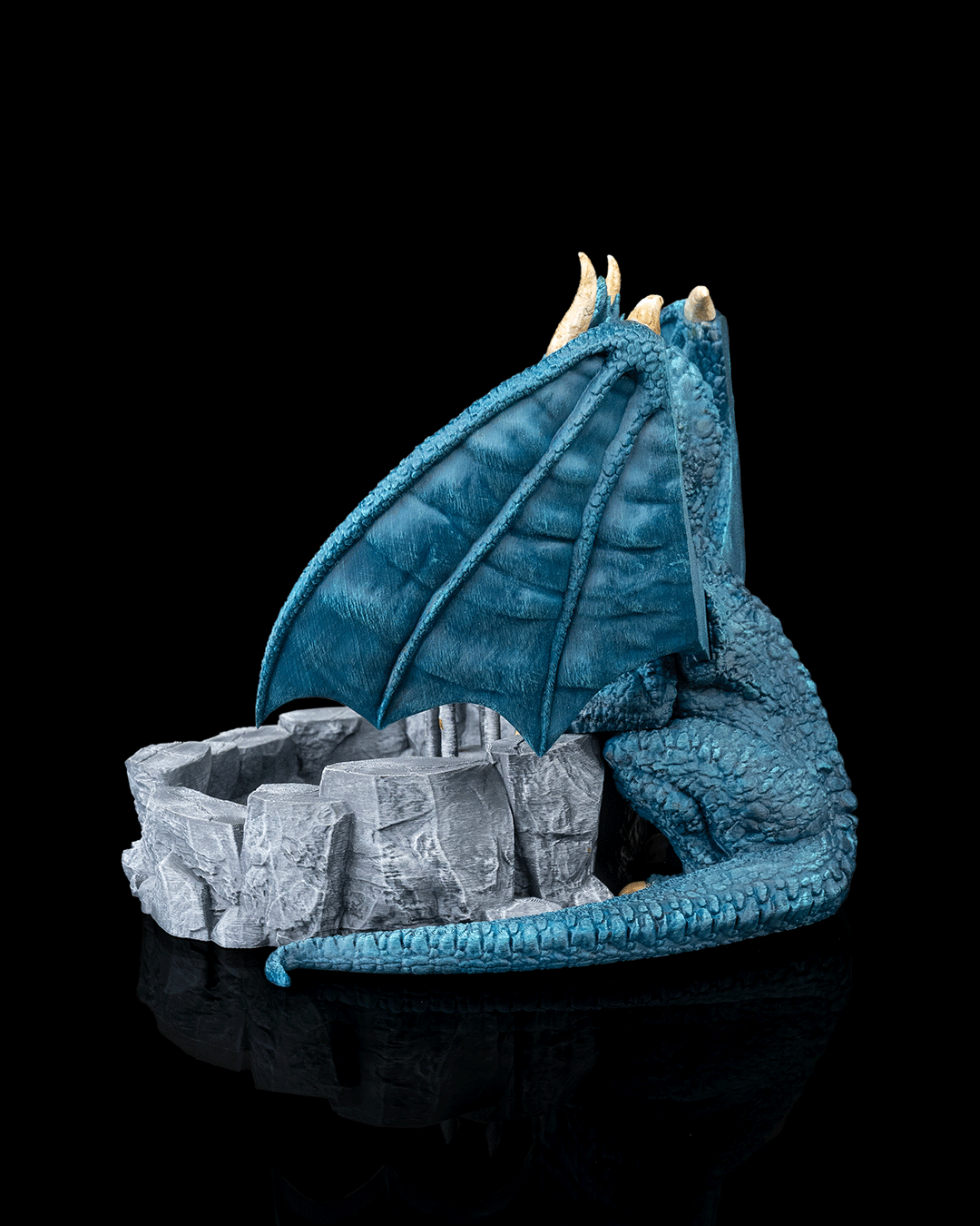 Blue dragon figurine with a nest of eggs on a black background