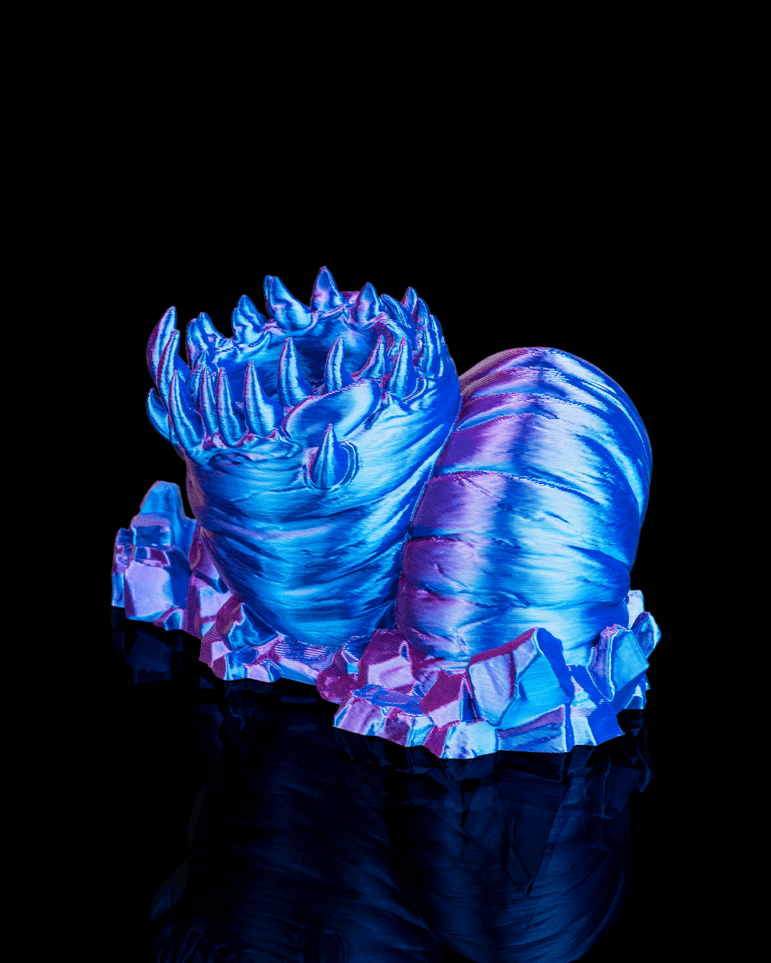Glowing blue and pink dragon-like creature on a black background