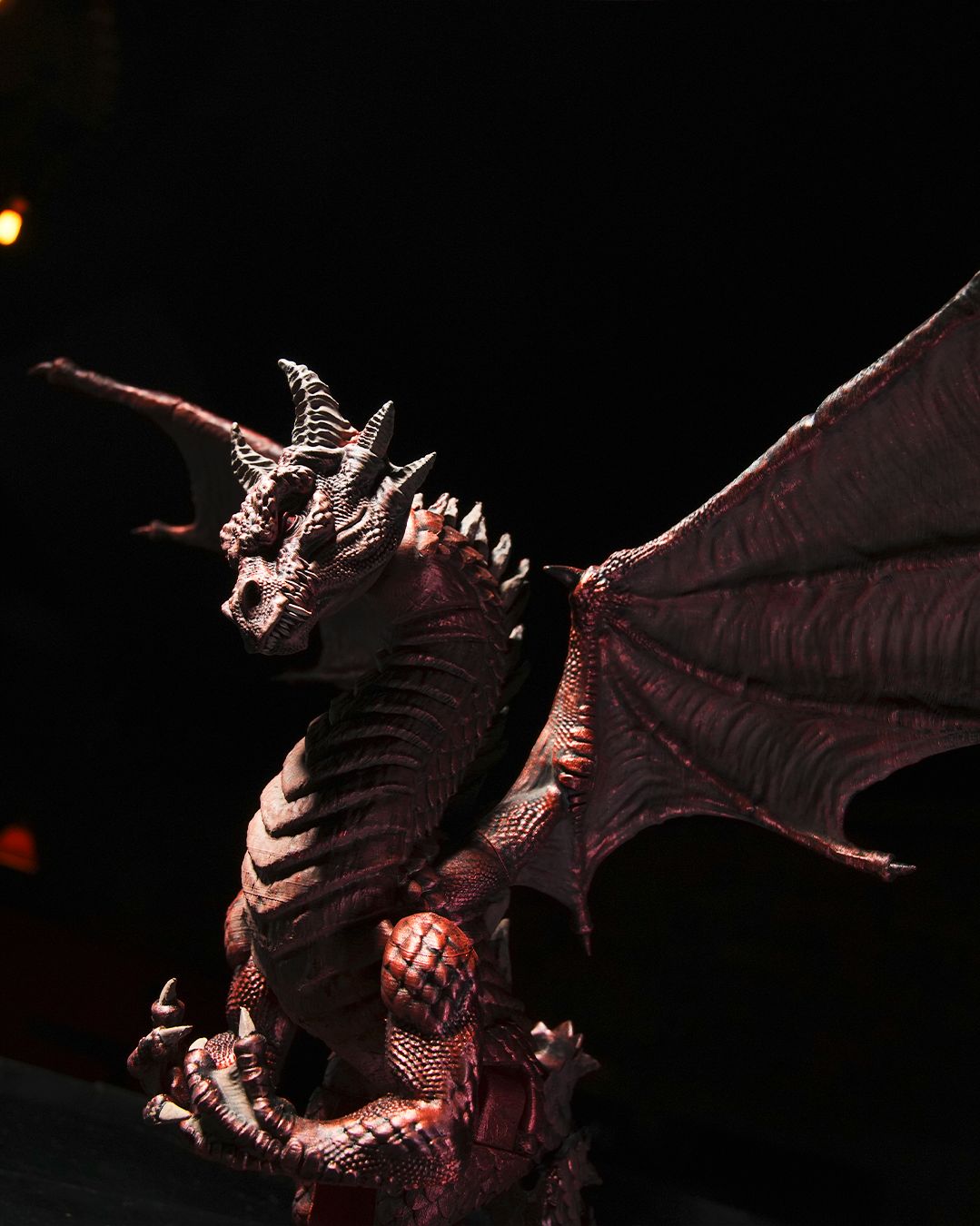 Dragon figurine with detailed scales and wings against a dark background