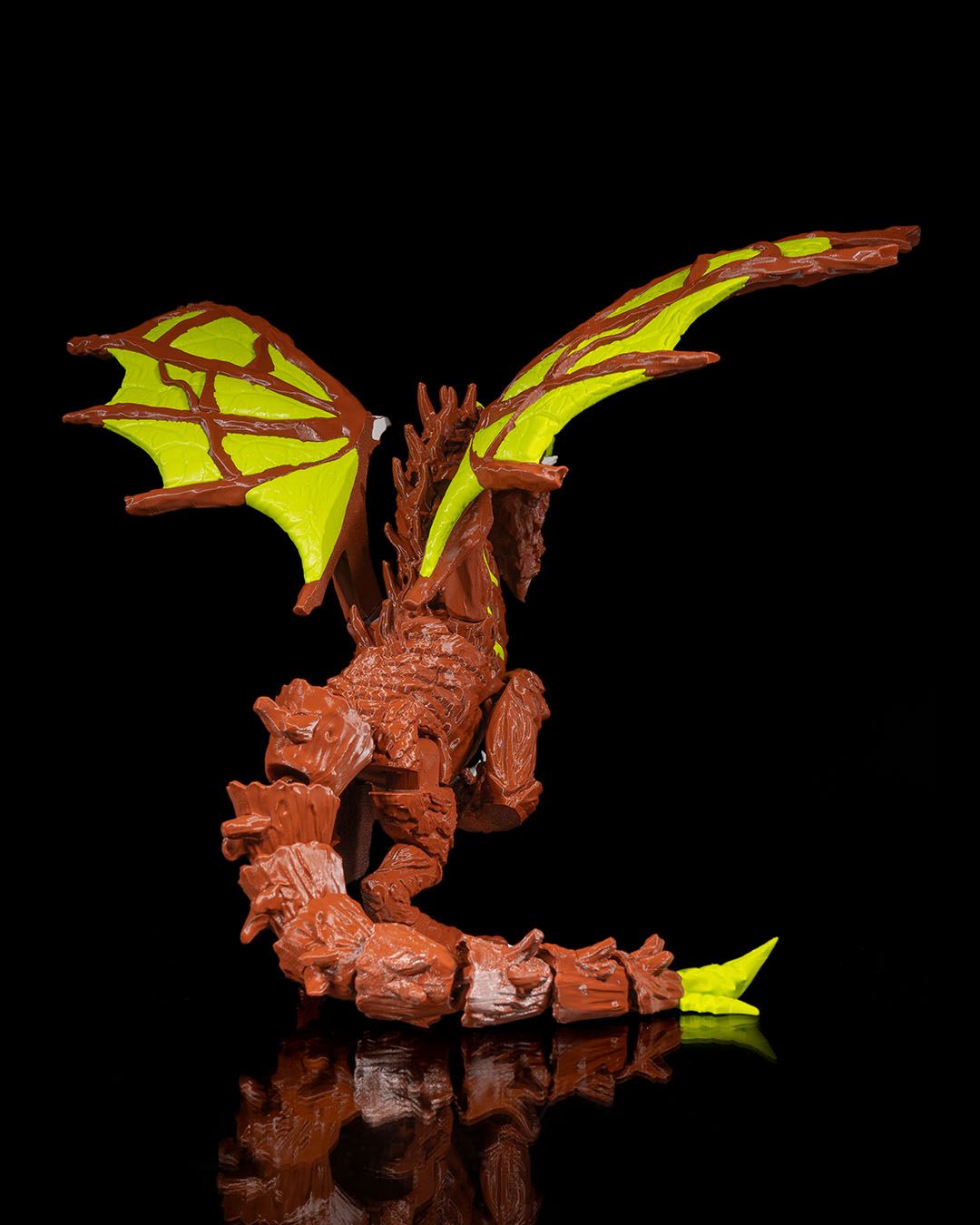 Moss Toy dragon figure with brown body and green wings on a black background
