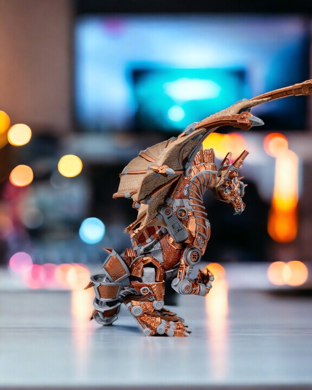 Mechanical dragon figurine on a reflective surface with blurred lights in the background