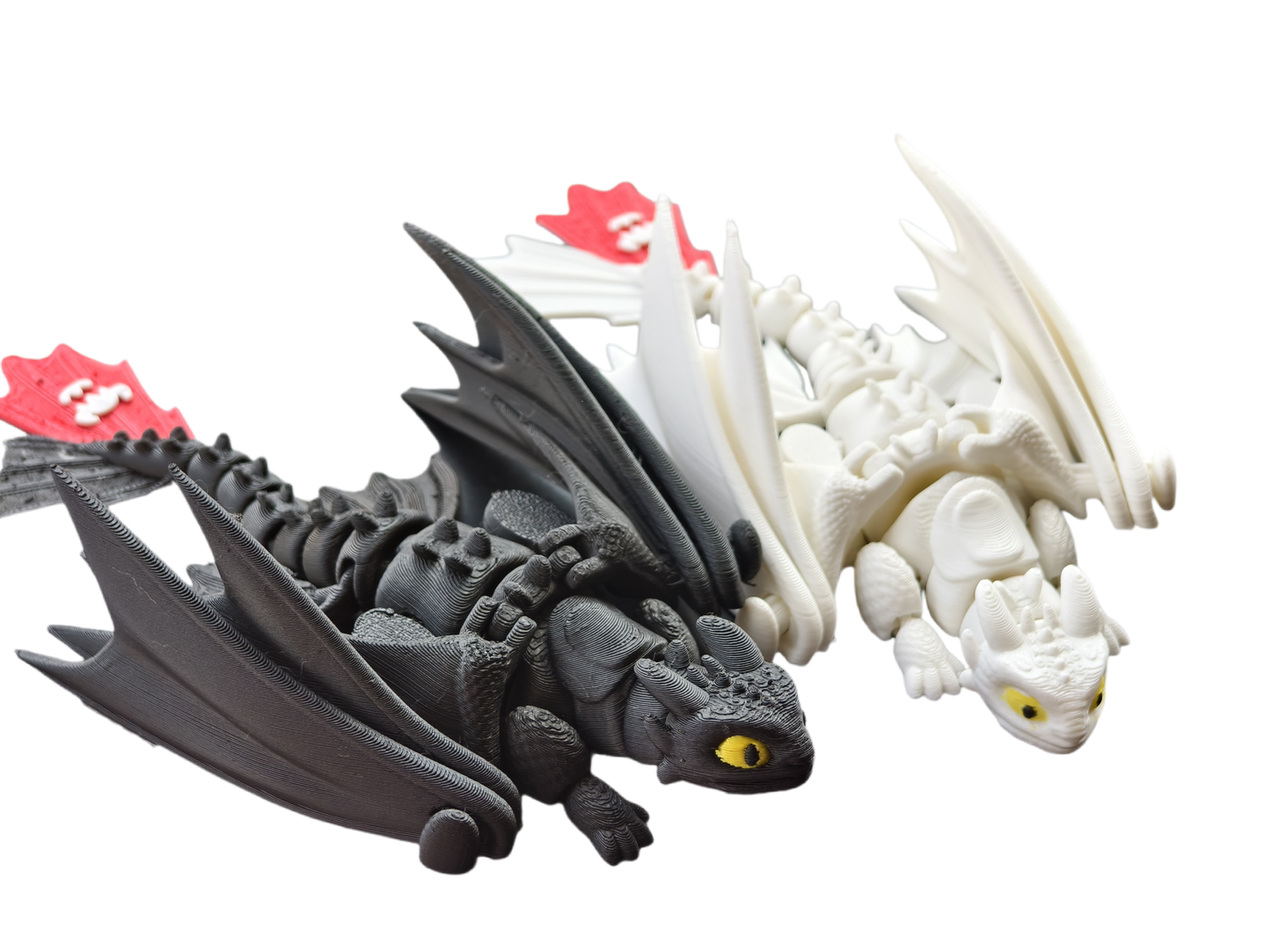 Two dragon figurines, one gray and one white, on a white background.