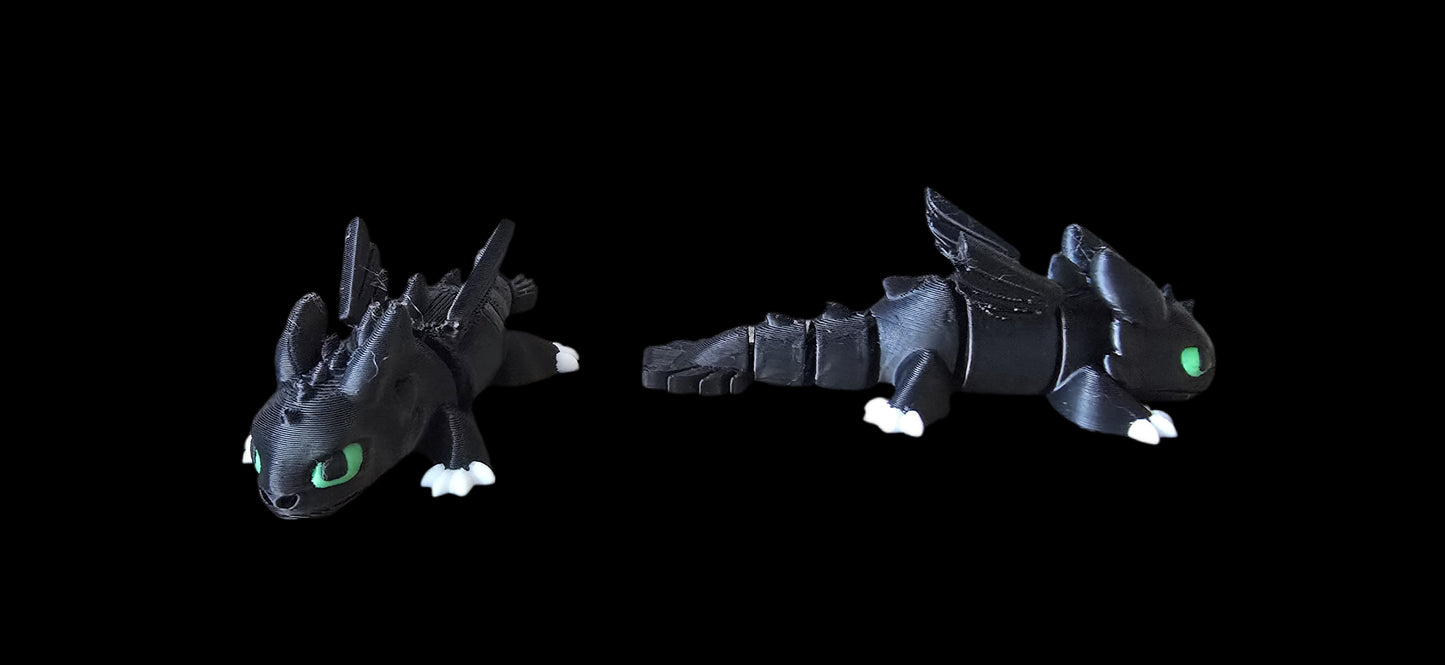 Two black dragon toys with green eyes on a black background
