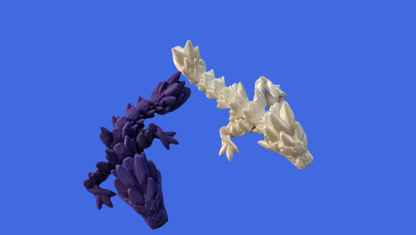 Two 3D-printed lizard models, one purple and one white, on a blue background.